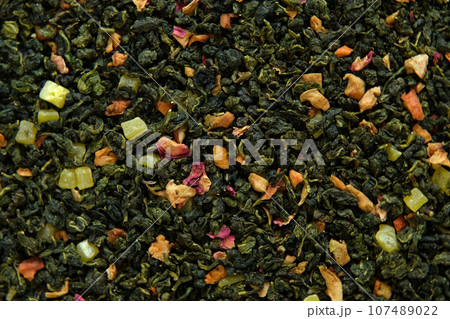 Loose Leaf Mango Pineapple Fruit Tea Wallpaper. Mix Black and Green Dry Tea Leaves. Close Up, Macro. Top View. Texture. Dried Tea is Spinning, Rotating. Abstract Food and Drink Background. Full Frame. 107489022