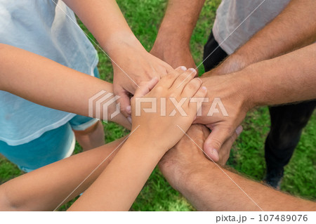 Joined hands as a team. Business teamwork. Close up group of multiracial friends meeting join hands together. Diversity people. Partnership volunteer community. Diverse multiethnic Partners. Top View Joined hands as a team. Business teamwork. Close up group of multiracial friends meeting join hands together. Diversity people. Partnership volunteer community. Diverse multiethnic Partners. Top View 107489076