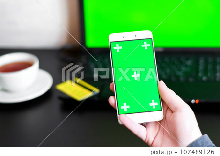 Close Up of a Smartphone with Green Screen for chroma key compositing. Person is shopping online with credit card and phone on internet. Concepts of Internet commerce, online banking to pay Close Up of a Smartphone with Green Screen for chroma key compositing. Person is shopping online with credit card and phone on internet. Concepts of Internet commerce, online banking to pay 107489126