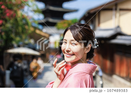 五重塔を背景に立つ着物姿の若い女性 107489383