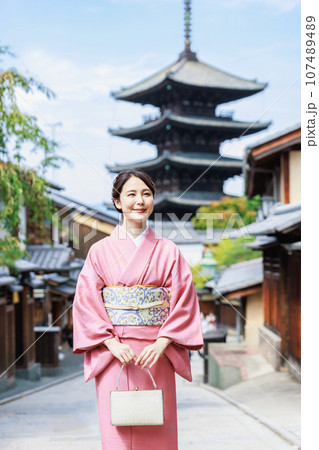 五重塔を背景に立つ着物姿の若い女性 107489489