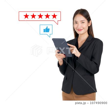 Businesswoman in black suit typing on tablet computer, show five stars best rating feedback and thumbs up icon. Customer service satisfaction evaluation concept. Businesswoman in black suit typing on tablet computer, show five stars best rating feedback and thumbs up icon. Customer service satisfaction evaluation concept. 107490900