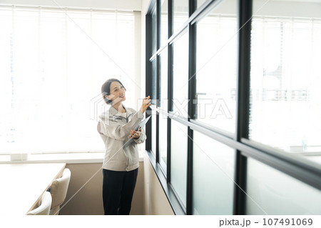 窓のチェックをする作業着の女性 窓のチェックをする作業着の女性 107491069