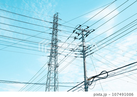 交差する高圧送電線と住宅街の電線と秋の空　ライトトーン 107491086