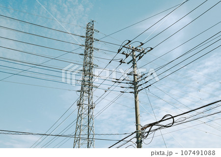 交差する高圧送電線と住宅街の電線と秋の空　フィルム調 107491088