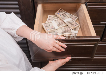 【たんすの引き出しに札束を隠す主婦】 107493002