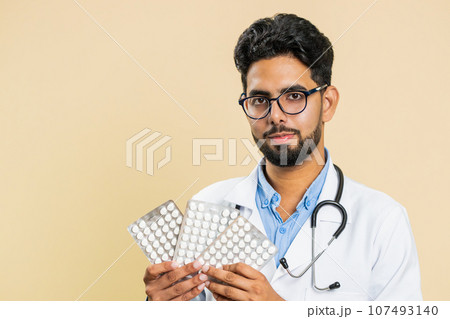 Indian doctor man show lot of tablet pills in blisters recommends drugs vitamin antibiotic treatment Indian doctor man show lot of tablet pills in blisters recommends drugs vitamin antibiotic treatment 107493140
