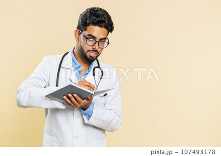 Doctor man making notes writing down thoughts with pen into notebook diary, to do list, good idea 107493178