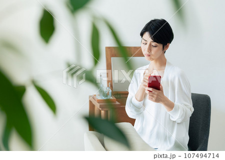 部屋でスマホを見る女性 部屋でスマホを見る女性 107494714