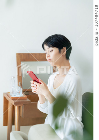 部屋でスマホを見る女性 部屋でスマホを見る女性 107494719