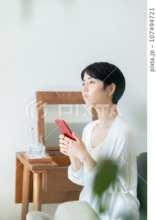 部屋でスマホを見る女性 部屋でスマホを見る女性 107494721