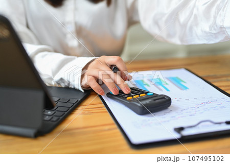 Closeup view of accountant working bookkeeping documents, checking financial data at office desk 107495102
