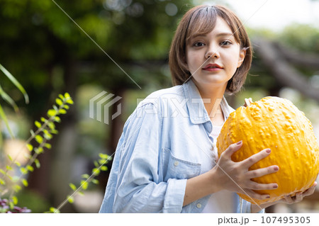 ハロウィン用のカボチャを持つ女性 ハロウィン用のカボチャを持つ女性 107495305