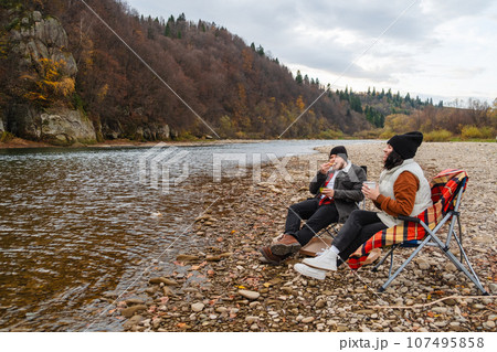 happy couple having picnic at river beach 107495858