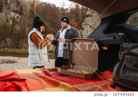 couple sitting in car trunk having picnic resting at nature couple sitting in car trunk having picnic resting at nature 107495885