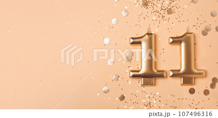 Gold candles in the form of number eleven. 107496316
