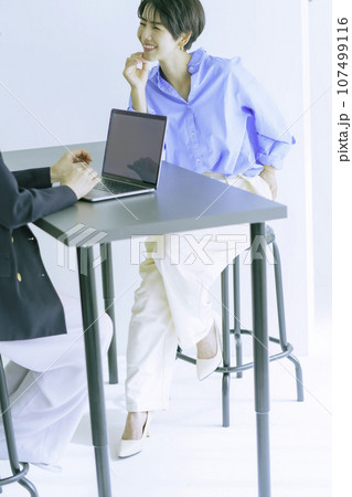 笑顔で会話する若い女性 縦位置 笑顔で会話する若い女性 縦位置 107499116