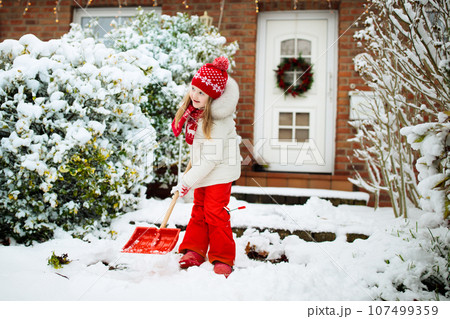 Child shoveling winter snow. Kids clear driveway. Child shoveling winter snow. Kids clear driveway. 107499359