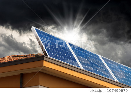 Solar Panels on the Roof of a House with Storm Clouds on Background Solar Panels on the Roof of a House with Storm Clouds on Background 107499679
