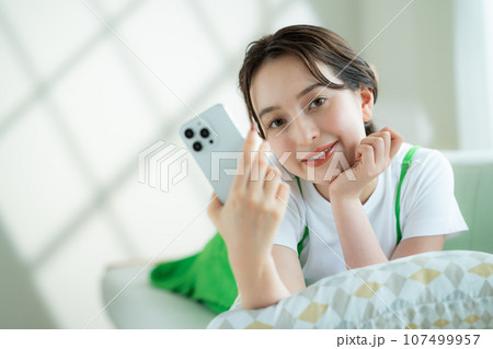 スマホを持つ若い女性 107499957