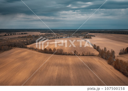 Autumn agricultural fields under dramatic sky with clouds Autumn agricultural fields under dramatic sky with clouds 107500158