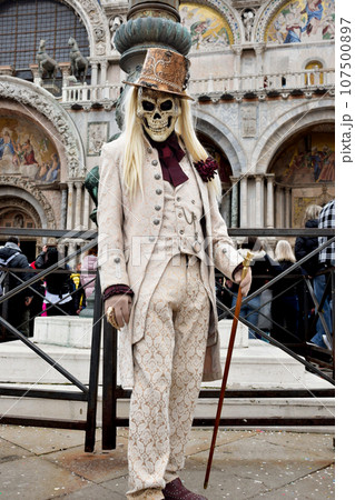 Person dressed up for Carnival of Venice wearing skull mask and white suit Person dressed up for Carnival of Venice wearing skull mask and white suit 107500897