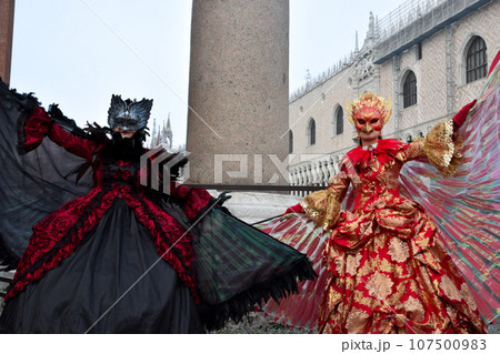 Couple of people dressed up for the Venice Carnival 107500983