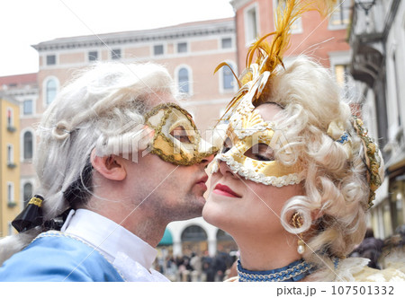 Couple kissing and dressed up for the Venice Carnival wearting contemporary clothes 107501332