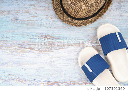 The Blue sandals and straw hat with copy-space on blue wooden background. 107501360