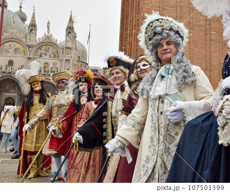 men and women dressed up at Venice carnival with authentic contemporary costumes 107501399