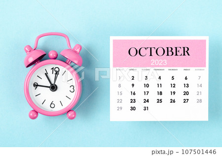 The October 2023 Monthly calendar for 2023 year with pink color alarm clock on blue background. The October 2023 Monthly calendar for 2023 year with pink color alarm clock on blue background. 107501446