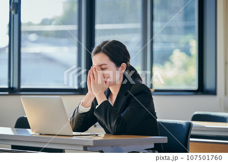 仕事中に考え事をする若い女性 仕事中に考え事をする若い女性 107501760