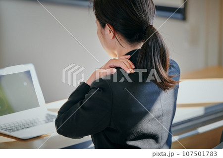デスクワークで肩が凝る若い女性 デスクワークで肩が凝る若い女性 107501783
