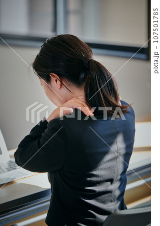 デスクワークで肩が凝る若い女性 デスクワークで肩が凝る若い女性 107501785