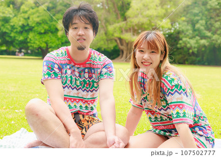 南半球の夏のクリスマスを芝生で楽しむ日本人カップル 南半球の夏のクリスマスを芝生で楽しむ日本人カップル 107502777