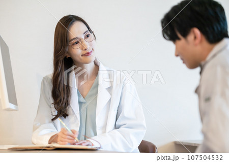 作業着姿の従業員とサポートする産業医 107504532