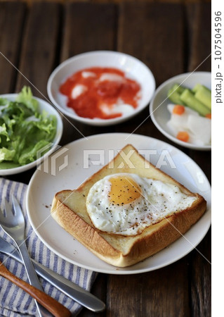 目玉焼きのせトーストとヨーグルトと野菜で朝ごはん 107504596