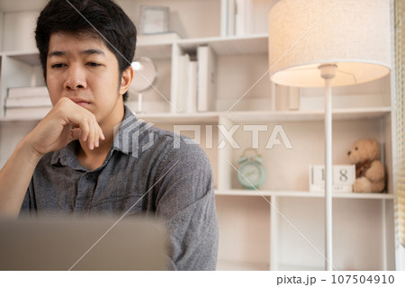 Stressed Young Businessman Facing Financial Loss in Corporate Office, Depressed man Dealing with Financial Setback, Stress and Money Problems, Anxiety and Worry Concept. Stressed Young Businessman Facing Financial Loss in Corporate Office, Depressed man Dealing with Financial Setback, Stress and Money Problems, Anxiety and Worry Concept. 107504910