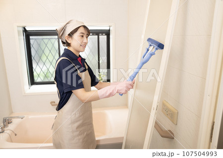 浴室の扉の清掃をするハウスクリーニングの女性作業員 浴室の扉の清掃をするハウスクリーニングの女性作業員 107504993
