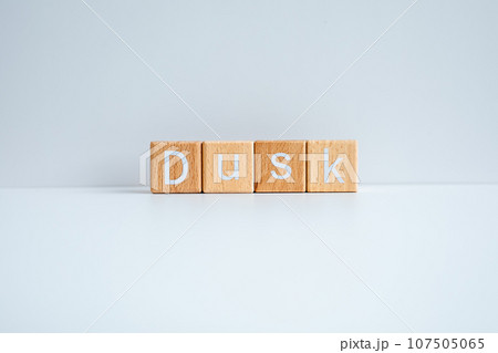 Wooden blocks form the text "Dusk" against a white background. Wooden blocks form the text "Dusk" against a white background. 107505065