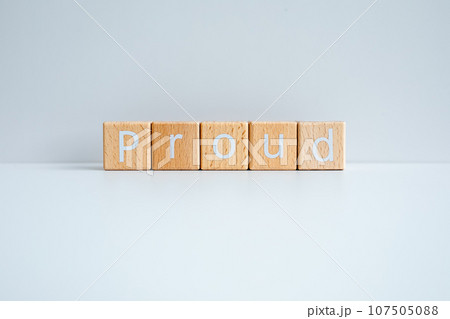 Wooden blocks form the text "Proud" against a white background. 107505088