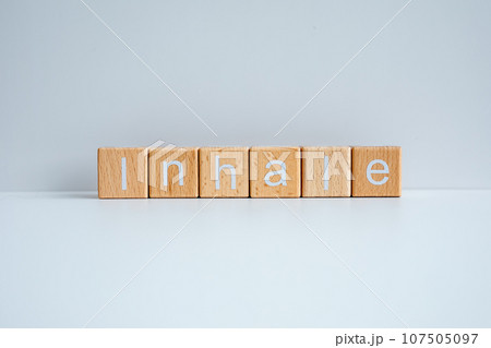 Wooden blocks form the text "Inhale" against a white background. Wooden blocks form the text "Inhale" against a white background. 107505097