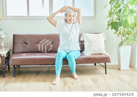 リビングでストレッチをするシニア女性 107505429