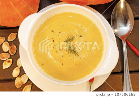 Pumpkin hot puree soup on a wooden table Pumpkin hot puree soup on a wooden table 107506168