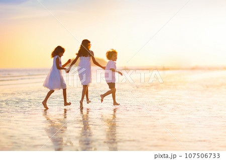 Child playing on ocean beach. Kid at sunset sea. Child playing on ocean beach. Kid at sunset sea. 107506733