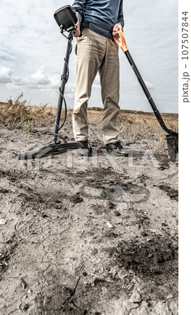 Archaeological and treasure hunting with a metal detector.Hunting for relics in the ground.Search for antiques.Soil research on gold nuggets.A man with a metal detector and a shovel.Finding research Archaeological and treasure hunting with a metal detector.Hunting for relics in the ground.Search for antiques.Soil research on gold nuggets.A man with a metal detector and a shovel.Finding research 107507844