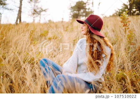 Stylish woman in hat enjoying autumn weather in the park. Fashion, style concept. 107510022