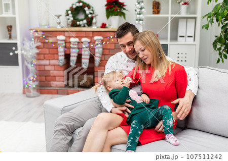 Close-up of a family of three cuddling on a couch. Close-up of a family of three cuddling on a couch. 107511242