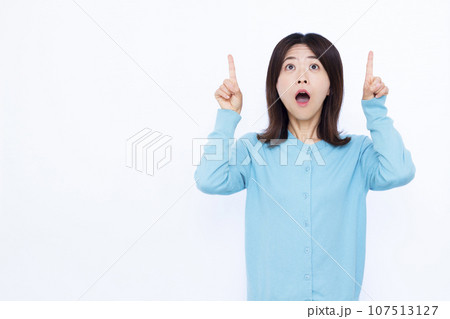 びっくりして天井を指差す30代の女性 107513127