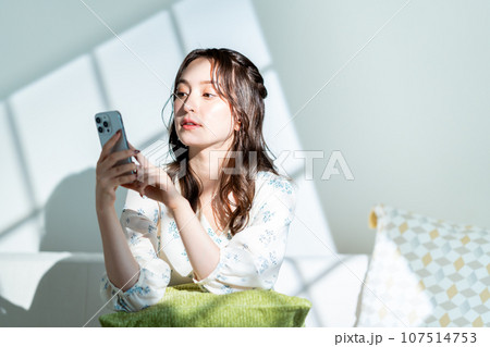 スマートフォンを操作する若い女性。 107514753